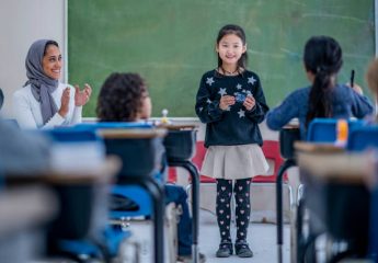 Multi-ethnic elementary students learning and presenting in class in front of the teacher