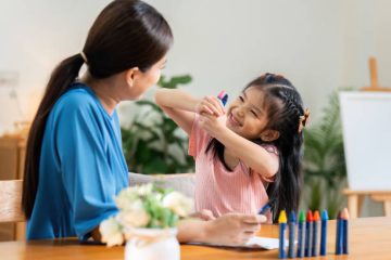 istockphoto-2022319135-612×612 Happy family. Mother and daughter drawing together. Adult woman helping to child girl.
